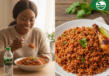 A woman smiling as she enjoys a plate of flavorful jollof rice served with grilled chicken, garnished with fresh herbs. Beside her is a chilled bottle of Avilan natural water. On the right side of the image, a close-up shows the delicious, well-seasoned jollof rice topped with cilantro and lime wedges. The Avila Naturals logo appears in the corner. Healthy Comfort Food.